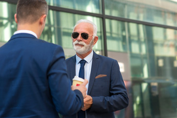  Senior businessman discussing something positive with his young colleague