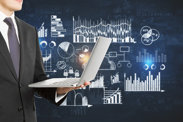 Wall Mural - Businessman holding laptop and drawing global marketing plan