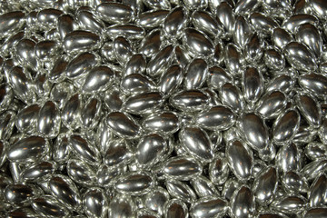 A pile of sweets of metallic color as a background. Candy close-up.