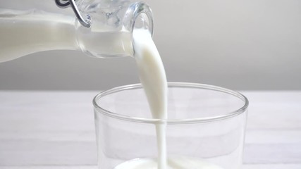 Canvas Print - Vertiendo leche en un vaso en la mesa