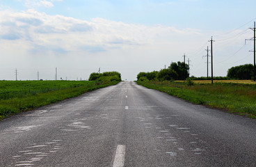 Sticker - An empty asphalt road through the rural landscape.