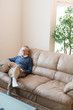 © imagenavi - Senior man relaxing on sofa