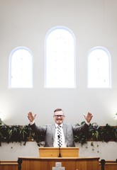 Sticker - Vertical shot of a male in a suit preaching words of the Holy Bible at the altar of a church