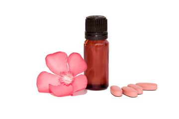 photo of cosmetic bottle with oil and pink pills and flowers isolated, on a white background. herbal vitamins