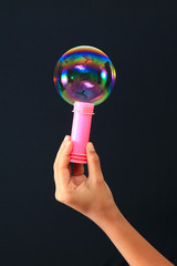 Rainbow soap bubble and red soap bubble bottle with hand