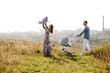 © Andriy Medvediuk - mom, dad and little girl having fun outdoors in the grass on summer day. mother's, father's and baby's day. Happy family for a walk with stoller outside the town.