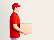 Home Delivery. Courier In Uniform Delivers Parcel To Door.