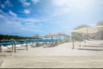 Wall Mural - Wooden table on the seafront among umbrellas and holiday sun