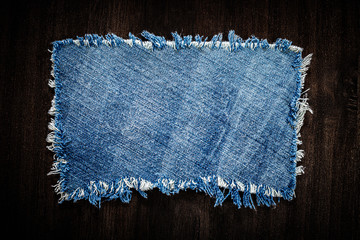 denim blue cloth frame patch on wooden table.