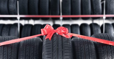 Poster - Car tires tied with red ribbon in auto store. Banner design