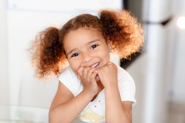 Wall Mural - Head shot portrait healthy attractive mixed race little girl with curly ringlets hairstyle and pretty face posing indoor looking at camera. Natural beauty innocence and new generation concept/