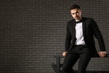 Poster - Handsome young man in elegant suit on dark background