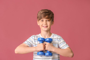 Wall Mural - Sporty little boy with dumbbells on color background