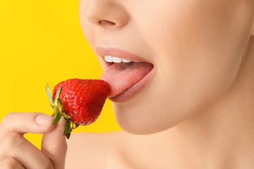 Sticker - Sexy young woman with strawberry on color background, closeup