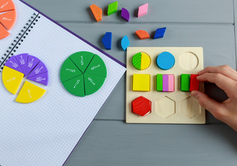 Wall Mural - Close up of Multicolored math fractions on the open notepad on gray wooden table. Interesting math for kids background. Education, back to school concept	