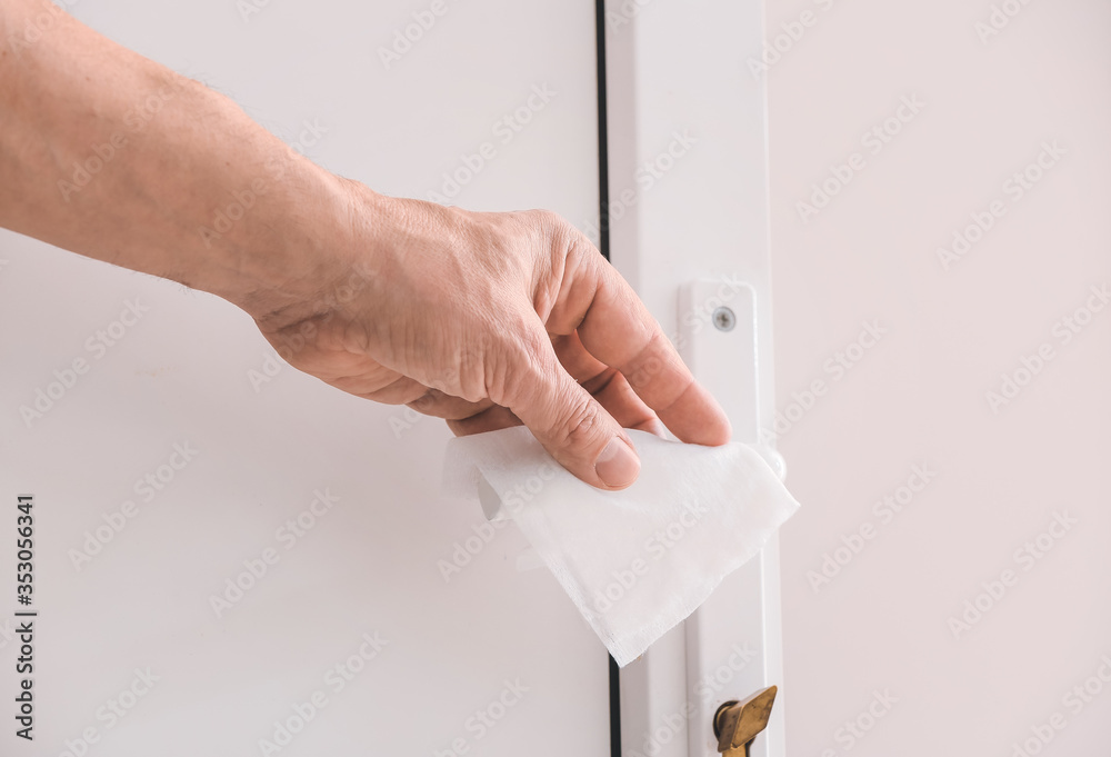 Man disinfecting door handle, closeup