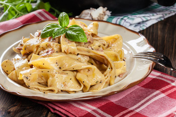 Canvas Print - Pappardelle pasta with prosciutto and cheese sauce on a plate