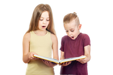 Wall Mural - Young surprised cute girl and boy are looking at the yellow book isolated on white background