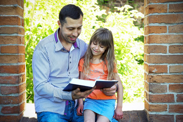 Wall Mural - young father with a  daughter reading the Bible
