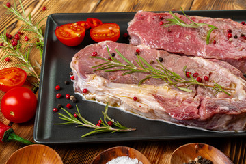 Wall Mural - Two raw beef steaks on dark wooden table