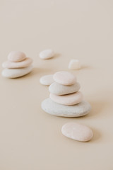 Wall Mural - Pale pastel stones stack on neutral stones. Flat lay, top view minimal spa concept.