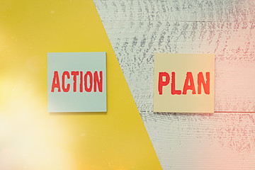 Text sign showing Action Plan. Business photo showcasing detailed plan outlining actions needed to reach goals or vision Two multicolor blank notepads colored paper sheet retro wooden background