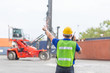 © eakgrungenerd - Foreman using radio communication control loading containers