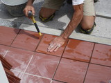 Fototapeta Tęcza - worker tiler metre laying tiles intent in his work