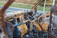 The Burned Out Wreckage Of An Old Van In A Road Layby 