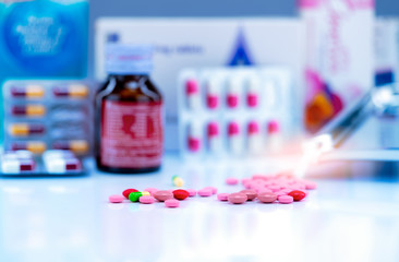 Canvas Print - Selective focus on tablets and capsule pills on blurred drug bottle, stainless steel drug tray, blister pack, and paper box of pill package. Pharmacy shop background. Colorful tablets and capsules.