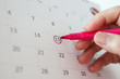 © Piman Khrutmuang - Hand with pen mark at 15th on calendar date