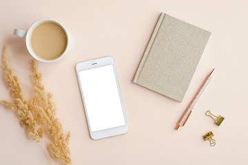 Wall Mural - Mockup of mobile phone with blank screen on home office desk table. Flat lay, top view.