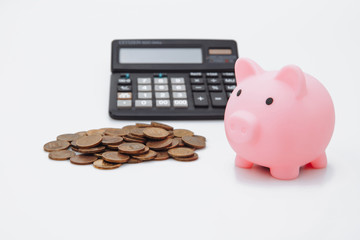 Pink piggy or coin bank or piggybank or money box, coins and calculator - finance and savings concept on white background.