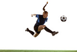 Fototapeta Sport - Young female soccer or football player with long hair kicking ball for the goal in flight, jumping high on white studio background. Concept of healthy lifestyle, professional sport, motion, movement.