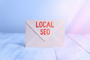 Poster - Handwriting text writing Local Seo. Conceptual photo helps businesses promote products and services to local customers Closed standing rectangular colored envelope old wooden vintage background