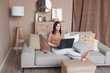 © Elena Kratovich - Relaxed female on sofa with laptop working at home