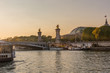 sunset over seine river in Paris with Grand Palais and Pont Alexandre III bridge in the background 