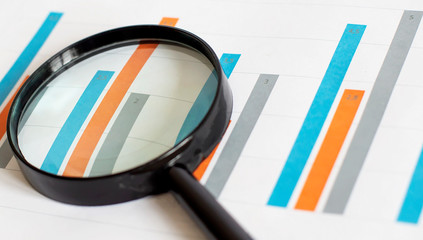 Poster - Top view of business chart on white table with magnifier