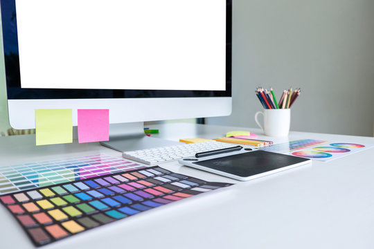 Modern office workplace with tablet, Graphic designer and color swatch samples at workplace