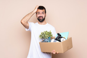 Wall Mural - Man holding a box and moving in new home over isolated background with an expression of frustration and not understanding