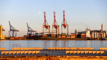 Canvas Print - The cranes in the port of Odessa at sunset with the moon in the background.