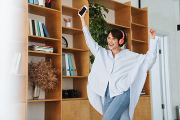 Poster - Smiling young woman entrepreneur listening to music