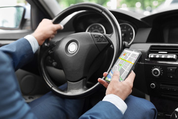 Wall Mural - Close up of man using smart phone with gps app in car