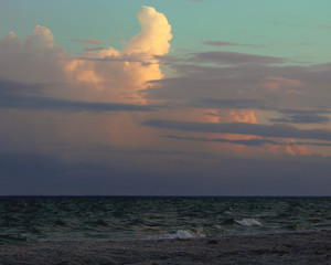 Sunset over the beach with face in the clouds looking down