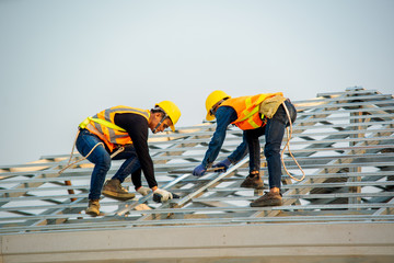 Poster - Handyman working on install the roof,Roofer builder working on roof structure of building on construction site.