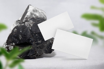 White minimal business card mockup with a big stone on table. PSD file.