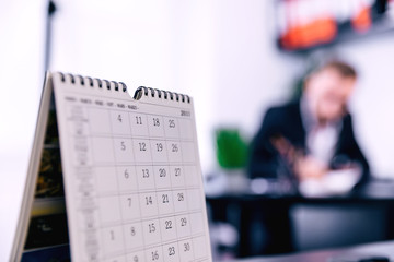 White Office Calendar 2020 on desk with blurred manager working