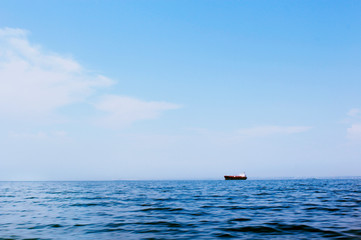 Seascape with a faraway cargo ship