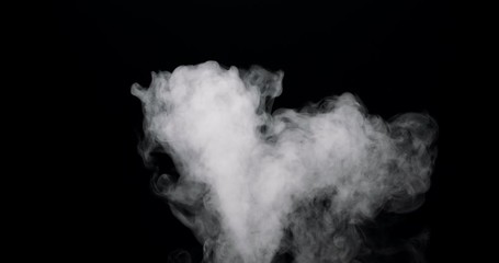 Wall Mural - cloud of smoke flowing in over a black background.