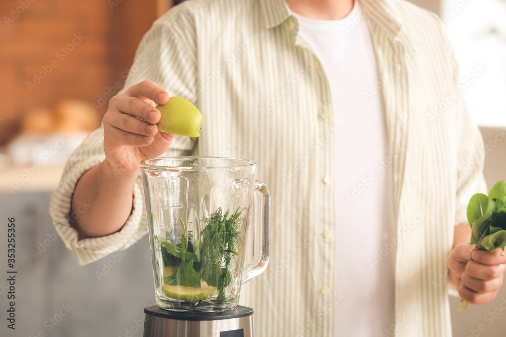 Man making healthy smoothie at home, closeup